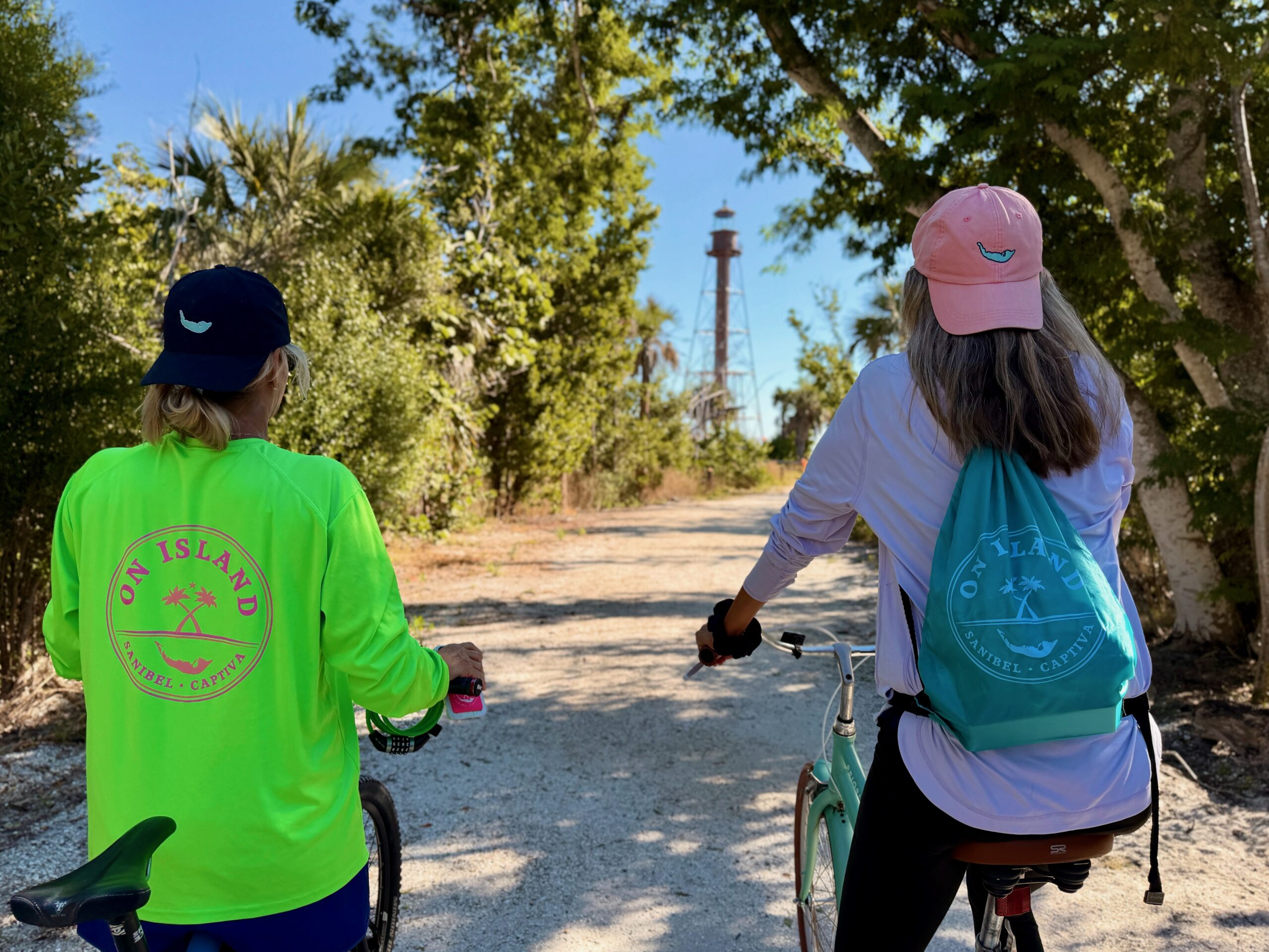 Two cyclists with Island Breeze eBikes at the Sanibel Island Lighthouse